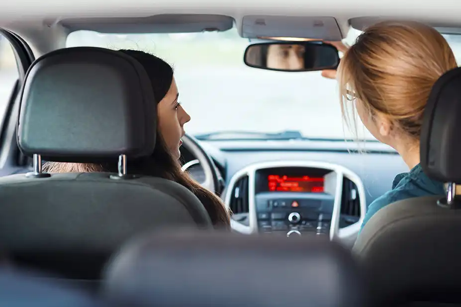 Student learning to drive with woman
