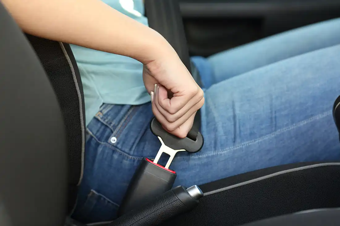 Teen buckling seatbelt in car